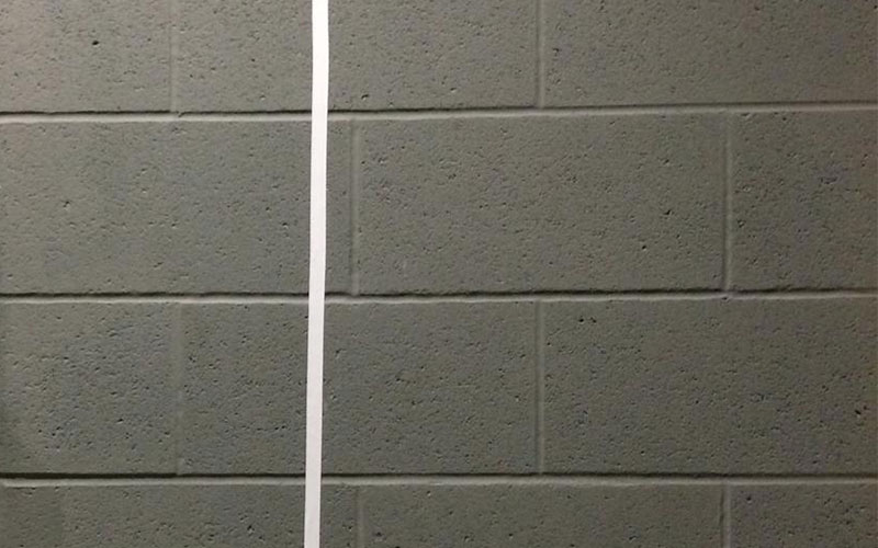 A taped white line on a grey wall